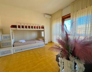 a bedroom with a bunk bed and a large window at NINFEA SEAVIEW APARTMENT - Elegant, Bright and Spacious, Steps from the Sea & Station in Nettuno