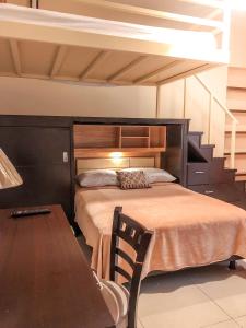 ein Schlafzimmer mit einem Bett und einem Tisch mit einem Schreibtisch in der Unterkunft Suites Hamburgo in Mexiko-Stadt