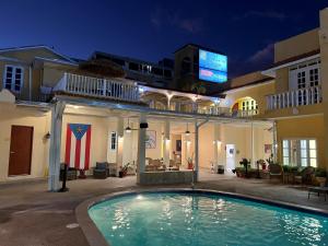 a swimming pool in front of a building at night at Hotel Villa del Sol in San Juan