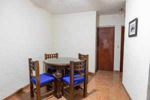 a dining room with a table with blue chairs at Casita Luna Sol in La Paz