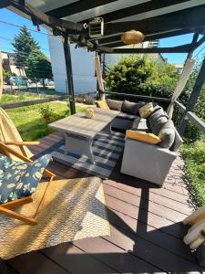 un patio avec un canapé, une table et des chaises dans l'établissement Lawendowe domki apartamenty, à Władysławowo