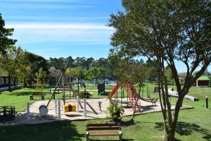 a park with a playground with a red slide at Cabañas La Vieja Chacra in Federación +7 photos
