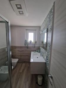 a bathroom with a sink and a toilet and a tub at La Casa del Borgo in Peccioli