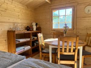 ein Esszimmer mit Tisch und Stühlen in einer Hütte in der Unterkunft Marika Puhkeküla - Nurgatalu Öömaja "shared bathroom" in Nõva