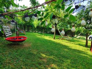 a red boat on the grass under a tree at Mitrovića kuća in Arandelovac
