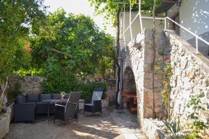 a patio with a couch and a table and chairs at Casa Placa in Kornić
