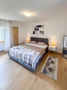 a bedroom with a large bed with two lamps and a rug at Casa Placa in Kornić