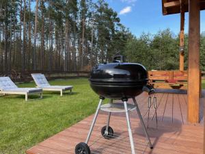 a grill sitting on a stand on a patio at Domek na Kaszubach 29-1 - Ostoja Bukowo in Borowy Młyn