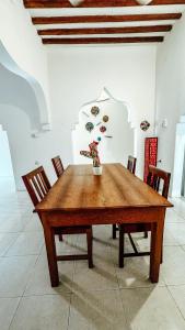 a wooden table with chairs and a vase with flowers on it at Family Villa - racoco villa in Jambiani