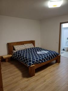 a bedroom with a bed with a blue and white comforter at Cazare Rasnov in Râşnov