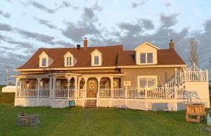 a large house with a large front porch at Chez Caro et Sylvain in Rimouski