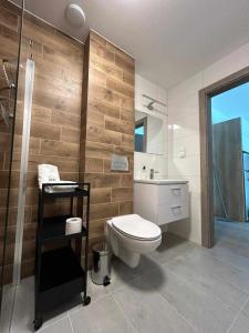 Un baño con inodoro, lavabo y ducha. en MoKa Apartamenty Sianożęty, en Sianożęty