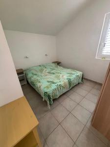 a bedroom with a bed with a green comforter at Kuća Roza in Rukavac