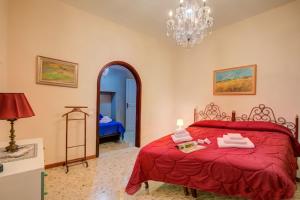 sypialnia z czerwonym łóżkiem i żyrandolem w obiekcie Villa Alberti Appartamento Emma - Happy Rentals w mieście Salò