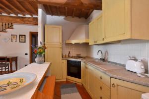 a kitchen with yellow cabinets and a sink and a counter at Casa Sofi - Happy Rentals in Monticiano