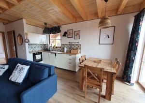 a living room with a blue couch and a table at Domek na Kaszubach 34-1 - Ostoja Bukowo in Borowy Młyn