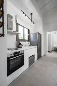 a white kitchen with a sink and a refrigerator at Astrum Luxury Suites in Vourvourou