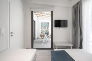 a white room with two beds and a dining room at Astrum Luxury Suites in Vourvourou