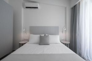 a bedroom with a large white bed with two tables at Astrum Luxury Suites in Vourvourou