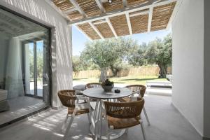 a dining room with a table and chairs on a patio at Astrum Luxury Suites in Vourvourou