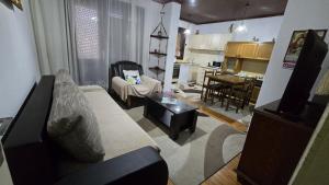 a living room with a couch and a kitchen at Sara Family Home in Struga