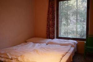 un letto non rifatto in una stanza con finestra di Chata Lesní Vyhlídka a Splzov
