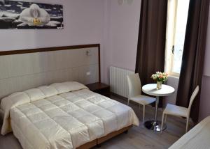 a bedroom with a bed and a table with chairs at Florence Stadium B&B in Florence +16 photos