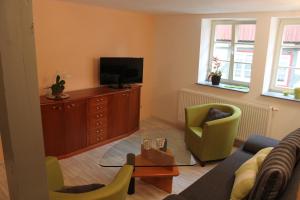 een woonkamer met een bank en een tv bij Ferienwohnungen Im Alten Handelshof in Quedlinburg