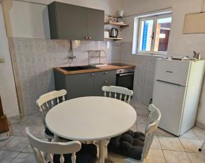 a kitchen with a table and chairs and a refrigerator at Apartment Melita in Murter +11 photos