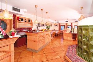 a kitchen with a bar and a dining room at Hotel Villetta Maria Cottage in Canazei