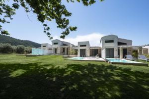 eine Außenansicht eines Hauses mit Garten in der Unterkunft Astrum Luxury Suites in Vourvourou