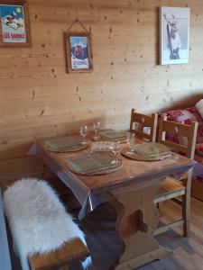 a wooden table with wine glasses on top of it at Le Cocon des Carroz, au centre de la station et proximité des pistes, apt 4 pers in Arâches-la-Frasse