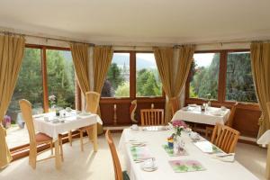 - une salle à manger avec des tables, des chaises et des fenêtres dans l'établissement Glede Knowe Guest House, à Innerleithen