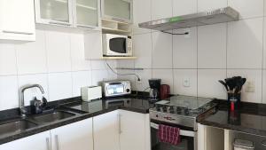 a kitchen with a sink and a stove at Apto 2Q Grande e Espaçoso in Curitiba +16 photos