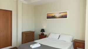 a bedroom with a bed and a picture on the wall at Apto 2Q Grande e Espaçoso in Curitiba