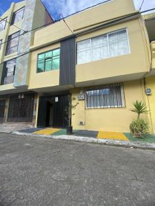 a large yellow building with a street in front of it at LA RRUCA de CHELITA para 6 personas in Baños