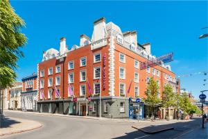 un grande edificio in mattoni rossi all'angolo di una strada di Mercure Nottingham City Centre Hotel a Nottingham