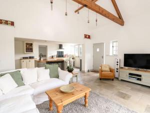 a living room with a white couch and a table at The Coach House in Cranwell