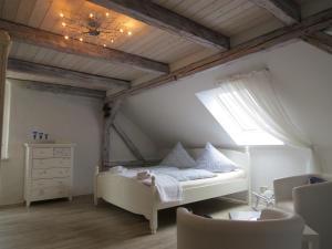 a bedroom with a white bed and a window at Märchenpension Rotkäppchen und der Wolf in Großwaltersdorf