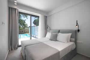 ein Schlafzimmer mit großem Bett und großem Fenster in der Unterkunft Astrum Luxury Suites in Vourvourou + 37 Fotos