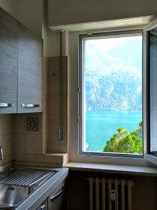 a kitchen window with a view of the ocean at verdazzurro lago in Abbadia Lariana