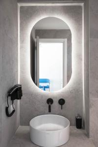 a bathroom with a white sink and a mirror at Astrum Luxury Suites in Vourvourou