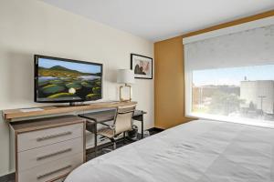 a bedroom with a bed and a desk with a television at Holiday Inn - Piscataway - Somerset, an IHG Hotel in Piscataway