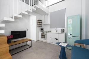 a living room with a kitchen and a staircase at Astrum Luxury Suites in Vourvourou
