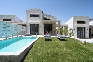 a villa with a swimming pool in front of a house at Astrum Luxury Suites in Vourvourou