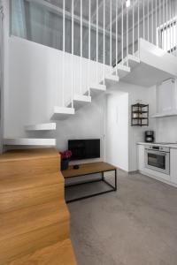 a living room with a staircase and a television at Astrum Luxury Suites in Vourvourou