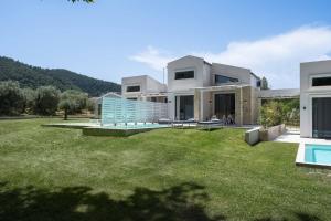 ein Haus mit einem großen Garten mit Pool in der Unterkunft Astrum Luxury Suites in Vourvourou