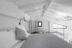a white bedroom with a large bed and a window at Astrum Luxury Suites in Vourvourou