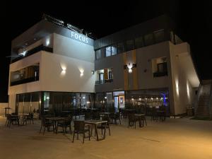Ein Gebäude mit Tischen und Stühlen bei Nacht in der Unterkunft Hotel FOCUS in Prilep