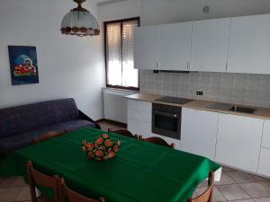 a kitchen with a table with a green table cloth at San Gabriele Arcangelo in Porto SantʼElpidio